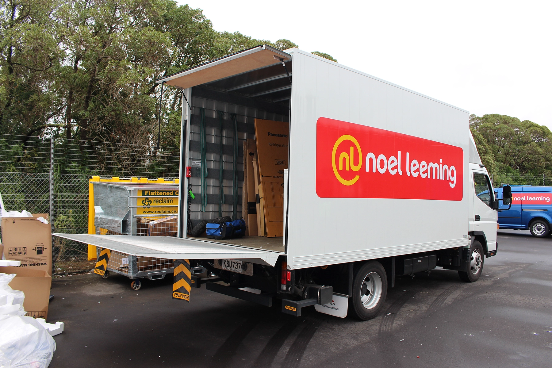 Palfinger cantilever tail lift extended behind a delivery truck.